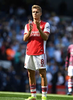 Manchester City v Arsenal 2021-22 Collection: Odegaard Salutes: Arsenal Fans' Unwavering Support in Manchester City Showdown