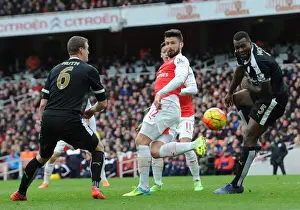 Olivier Giroud (Arsenal) heads the ball between Robert Huth and Wes Morgan (Leicester)