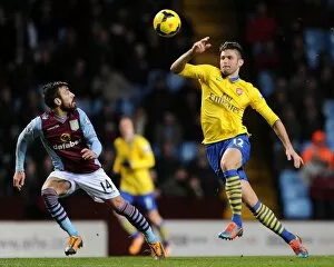 Images Dated 13th January 2014: Olivier Giroud Faces Pressure from Antonio Luna in Aston Villa vs. Arsenal Premier League Clash