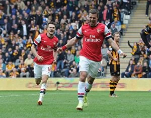 Hull City Collection: Podolski and Ramsey's Unforgettable Moment: Arsenal's Winning Goals Against Hull City (2014)