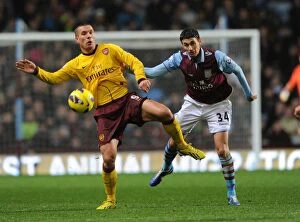 Images Dated 24th November 2012: Podolski vs. Lowton: A Battle at Villa Park - Arsenal vs. Aston Villa, Premier League 2012-13