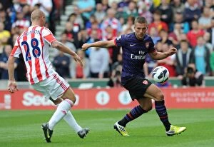 Images Dated 26th August 2012: Podolski vs. Wilkinson: Battle at Britannia Stadium - Stoke City vs. Arsenal, 2012-13 Premier League
