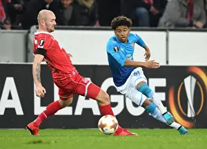 FC Koln V Arsenal 2017-18 Prints: Reiss Nelson vs. Konstantin Rausch: Battle in the Europa League between FC Koln and Arsenal FC