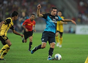 Malaysia XI v Arsenal Collection: Robin van Persie (Arsenal) Mohd Ismail (Malaysia). Malaysia XI 0: 4 Arsenal