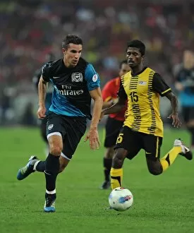 Malaysia XI v Arsenal Collection: Robin van Persie (Arsenal) Mohd Muslin (Malaysia). Malaysia XI 0: 4 Arsenal
