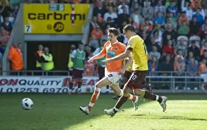 Images Dated 10th April 2011: Robin van Persie shoots past Blackpool goalkeeper Richard Kindson to score the 3rd Arsenal goal