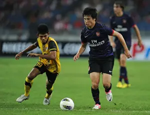 Malaysia XI V Arsenal 2012-13 Prints: Ryo Miyaichi vs Ahmad Shakir Md Ali: A Football Showdown in the 2012-13 Arsenal Pre-Season Match in Malaysia
