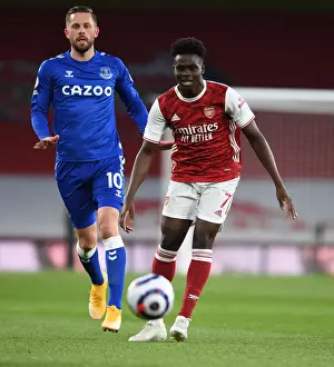 Saka Outsmarts Sigurdsson: Arsenal's Star Winger Dazzles in Empty Emirates Stadium