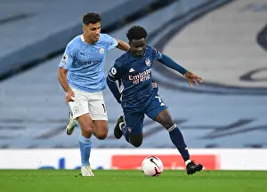 Manchester City V Arsenal 2020-21 Prints: Saka vs Rodrigo: A Premier League Showdown - Bukayo Saka of Arsenal Clashes with Manchester City's Rodrigo (2020-21)