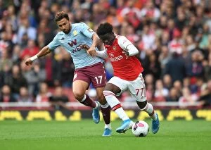 Arsenal v Aston Villa 2019-20 Collection: Saka vs Trezeguet: A Premier League Battle at Emirates Stadium