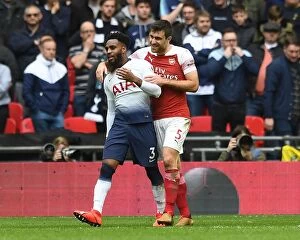 Tottenham Hotspur v Arsenal 2018-19 Collection: Sokratis and Danny Rose Embrace Amidst Premier League Rivalry: Tottenham vs. Arsenal