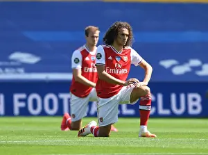 Brighton And Hove Albion V Arsenal 2019-20 Prints: Empty Stands: Matteo Guendouzi Kneels at Brighton & Hove Albion vs Arsenal FC
