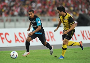 Malaysia XI v Arsenal Collection: Theo Walcott (Arsenal) Mohd Putra (Malaysia). Malaysia XI 0: 4 Arsenal, Bukit Jalil Stadium