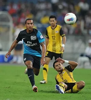 Malaysia XI v Arsenal Collection: Theo Walcott (Arsenal) Mohd Zafuan (Malaysia). Malaysia XI 0: 4 Arsenal