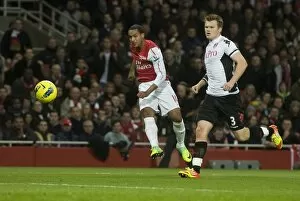 Theo Walcott of Arsenal shoots past John Arne Riise of Fulham during the Barclays Premier League match between Arsenal