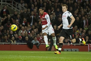 Theo Walcott of Arsenal shoots past John Arne Riise of Fulham during the Barclays Premier League match between Arsenal Theo Walcott of Arsenal shoots past John Arne Riise of Fulham during the Barclays Premier League match between Arsenal