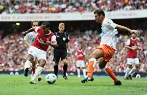 Images Dated 21st August 2010: Theo Walcott shoots past Blackpool defender Dekel Keinan to score the 3rd Arsenal goal