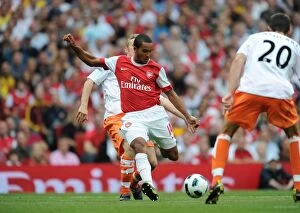 Images Dated 21st August 2010: Theo Walcott shoots past Blackpool goalkeeper Matthew Gilks to score the 5th Arsenal goal