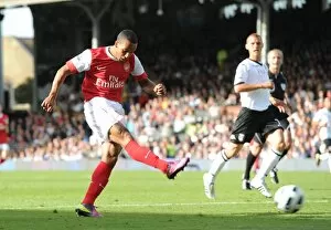 Fulham v Arsenal 2010-11 Collection: Theo Walcott shoots past Fulham goalkeeper Mark Schwarzer to score the 2nd Arsenal goal