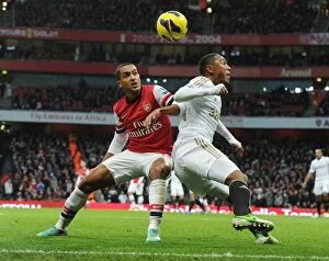 Arsenal v Swansea 2012-13 Collection: Theo Walcott vs. Jonathan De Guzman: Intense Battle at Arsenal v Swansea (2012-13)