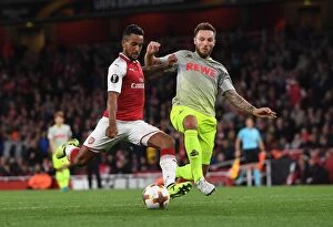 Arsenal v FC Köln 2017-18 Collection: Theo Walcott vs Jorge Mere: A Tense Shooting Showdown in Arsenal FC vs 1