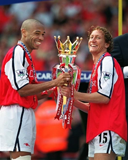 Thierry Henry and Ray Parlour lift the F. A. Barclaycard Premiership Trophy