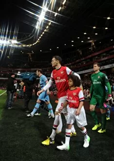 Thomas Vermaelen (Arsenal) walks out onto the pitch with the mascot. Arsenal 5: 1 West Ham United