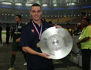 Malaysia XI v Arsenal Collection: Thomas Vermaelen (Arsenal) with the winners trophy after the match. Malaysia XI 0: 4 Arsenal