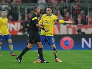 Bayern Munich v Arsenal 2013-14 Collection: Thomas Vermaelen Confronts Referee Svein Oddvar Moen in Tense Arsenal-Bayern Clash