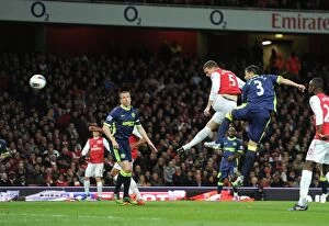 Images Dated 16th April 2012: Thomas Vermaelen Leaps Past Antolin Alcaraz to Score for Arsenal Against Wigan Athletic, April 2012