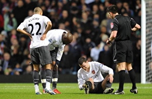 Aston Villa v Arsenal 2009-10 Gallery: Thomas Vermaelen sits injuryed on the pitch as Gael Clichy and William Gallas