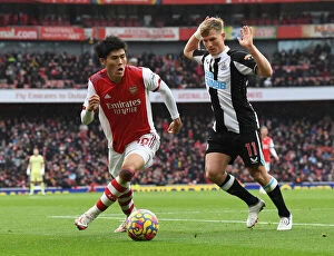 Arsenal v Newcastle United 2021-22 Collection: Tomiyasu vs Ritchie: A Battle of Wits in the Arsenal vs Newcastle Premier League Clash