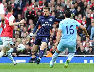 Wojciech Szczesny (Arsenal) clears the ball away from Sergio Aguero (Man City)